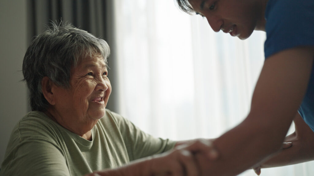Image of nurse helping elderly lady stand up