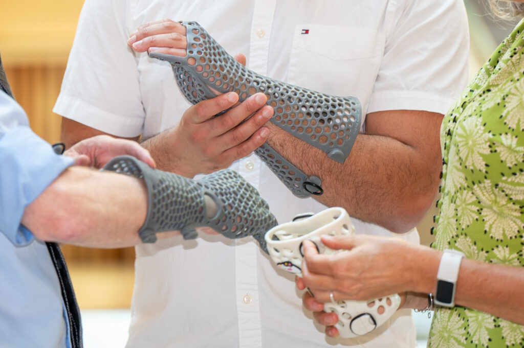 People trying on 3D casts from Additive Design at the Leeds Research and Innovation Conference